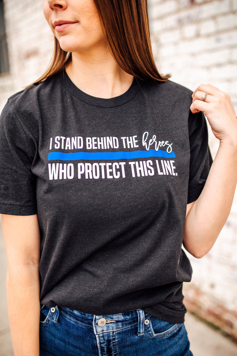 I Stand Behind The Heroes Who Protect This Line © Unisex Top (Black Heather)